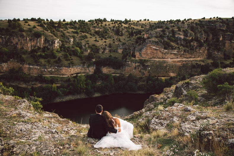 Fotografia y video boda, novio sentado en el campo de espalda